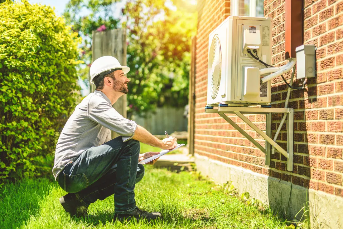 A residential heat pump outdoor unit being inspected